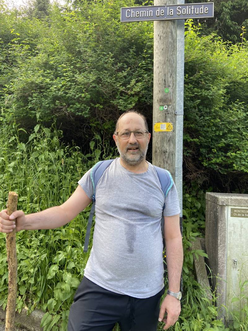 Moi, posant devant un poteau avec l’inscription “Chemin de la Solitude”