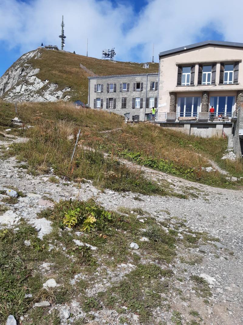 Un double bâtiment, le restaurant devant, l’hôtel derrière; en arrière-plan le relais des Rochers de Naye, marquant le sommet.