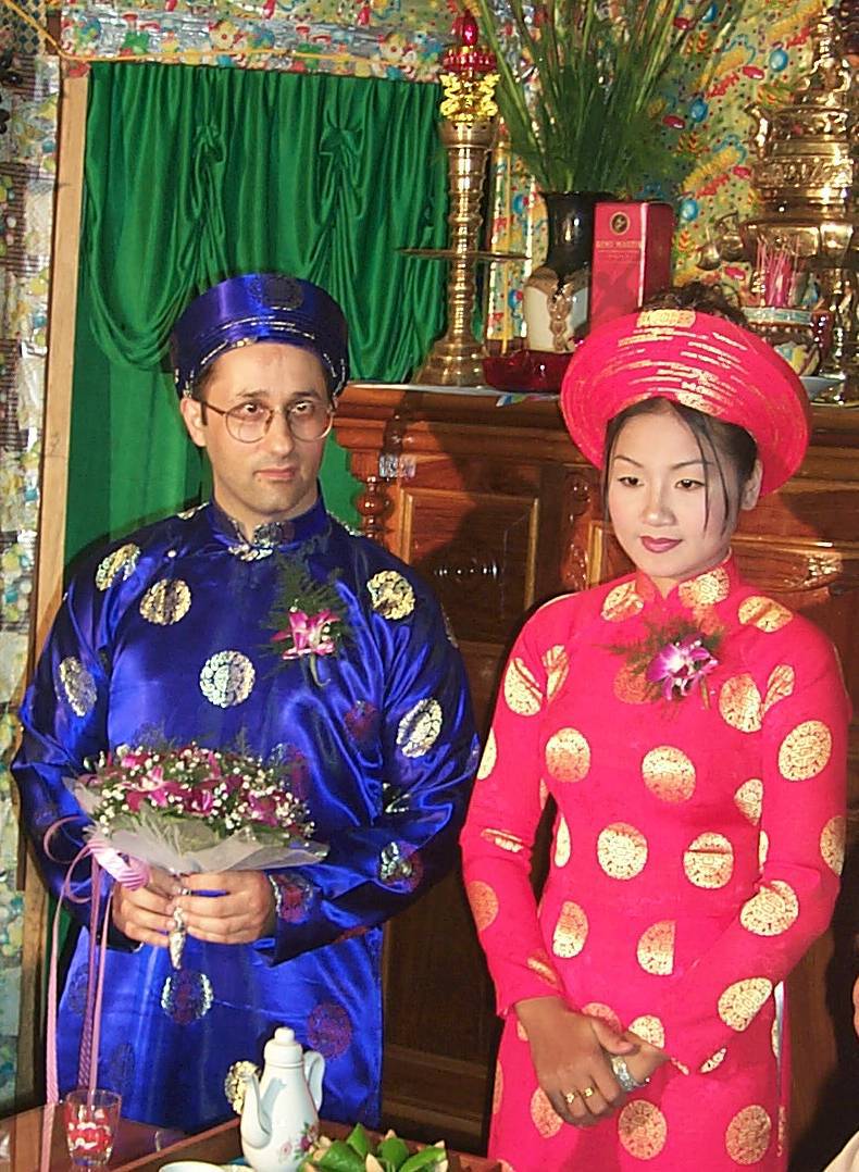 Mon épouse et moi en tenues traditionnelles vietnamiennes lors de notre mariage: “ao dai” et chapeau roses pour elle, bleus pour moi